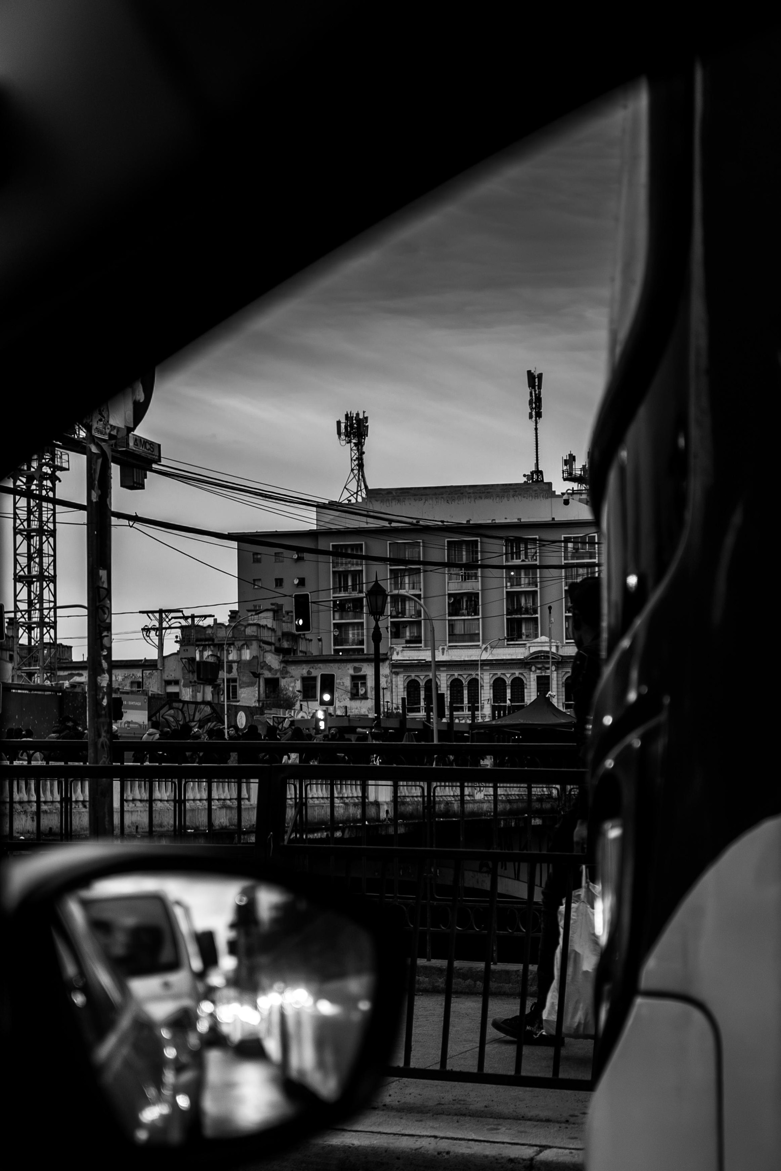 La calle y los edificios vistos desde el carro, con el espejo retrovisor en primer plano