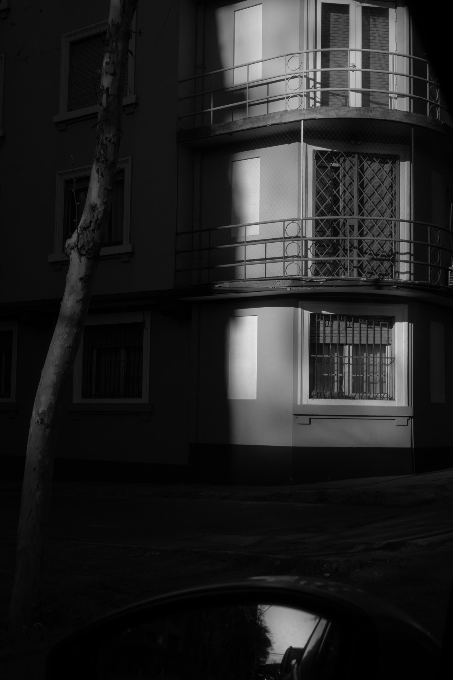 La luz de la tarde dibujando tres rectángulos en la fachada de un edificio, vista desde el carro